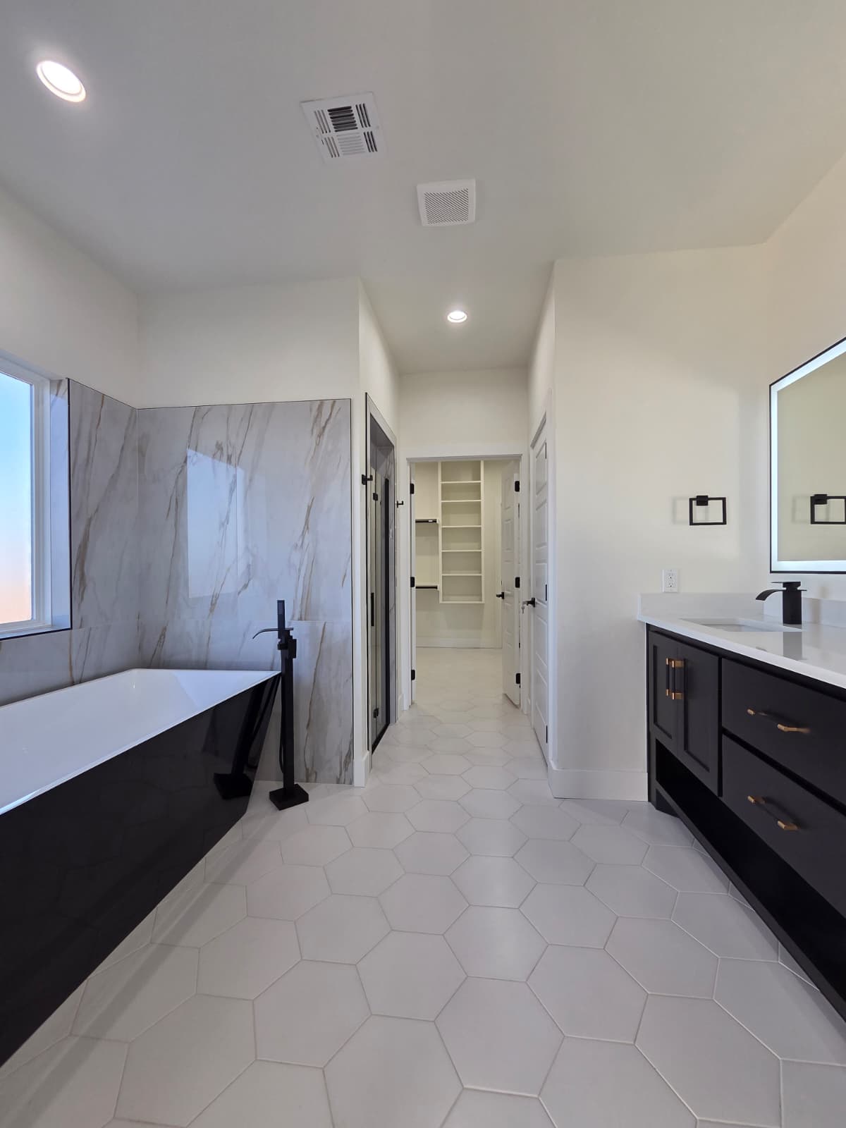 Master bathroom with freestanding tub and marble walls